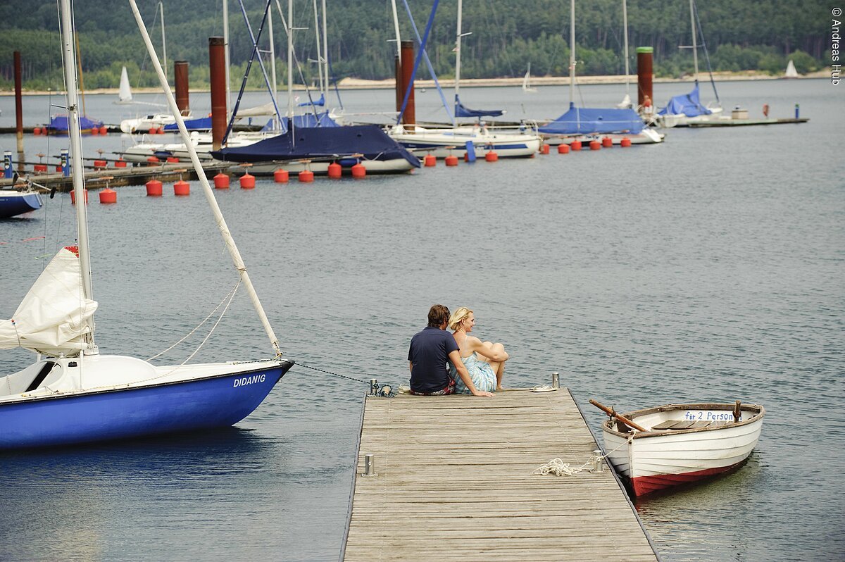 Ein Paar genießt die Zeit an einem Steg des Segelhafens im Seezentrum Ramsberg am Großen Brombachsee