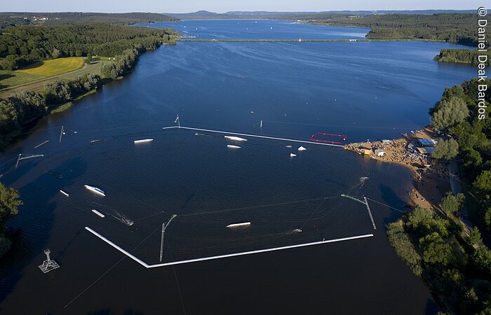 Luftbild Wakeboardanlage Absberg Luftbild von der Wakeboardanlage. Im See Hindernisse für die Wakeboardfahrer. Am See ein Strand mit vielen Besuchern. Der See ist umgeben von grünen Bäumen und Sträuchern.