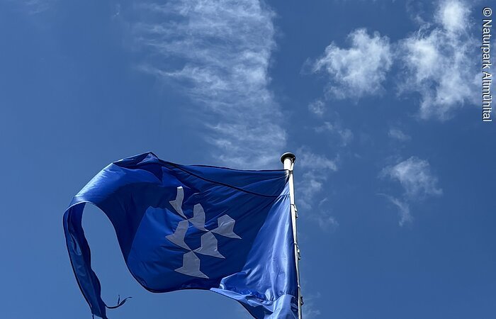 Flagge Burg Pappenheim Vor einem blauen Himmel mit wenigen Wolken ist die blaue Flagge der Burg Pappenheim zu sehen.