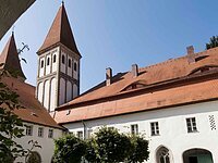 Der Innenhof des Kloster Heidenheims. Große weiße Gebäude mit rotem Ziegeldach und Turm.