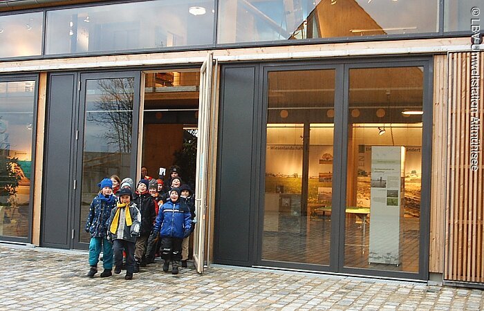 Kinder kommen aus dem Ausstellungsgebäude maschiert.