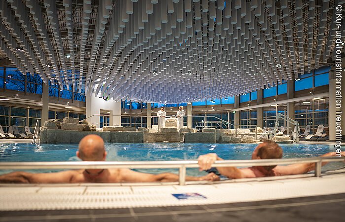 Zwei Männer liegen im Düsenbereich des Innenbeckens Zwei Männer liegen im Düsenbereich des Innenbeckens