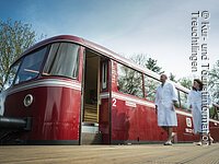 Vor der Schienenbus-Sauna läuft ein Paar im Bademantel Vor der Schienenbus-Sauna läuft ein Paar im Bademantel