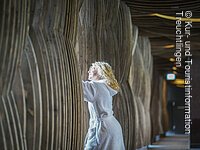 Im Weitwinkel, Frau schaut aus hözernen Vorhang raus Im Weitwinkel, Frau schaut aus hözernen Vorhang raus