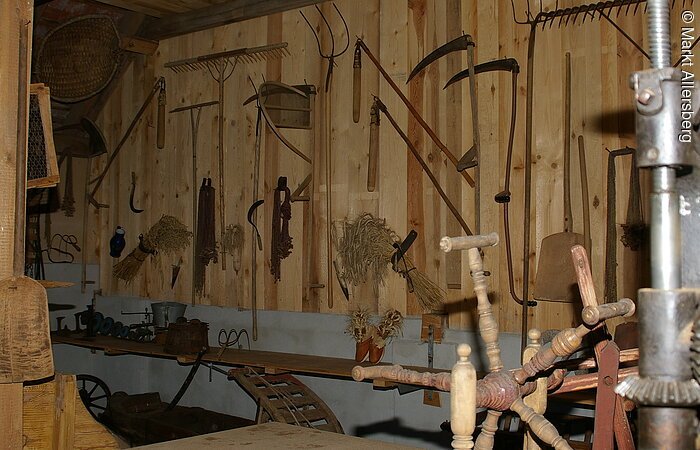 Im alten Kuhstall hängen verschiedene Werkzeuge von früher.