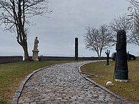 Skulpturen Weg Ein gepflasterter Weg führt entlang von einzelnen Skulpturen. Die Skulpturen stehen auf grünen Wiesen.