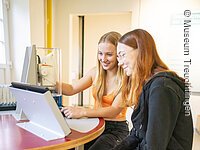 Mikroskope Entdeckerwerkstatt 2 Jugendliche sitzen in der Entdeckerwerkstatt und arbeiten mit den Mikroskopen in der Ausstellung.