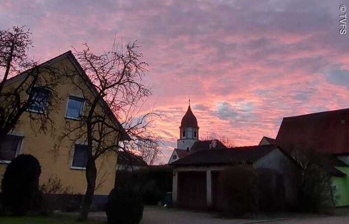 Horizont Ein lila-oragener Horizont über Häusern und einem Kirchturm.