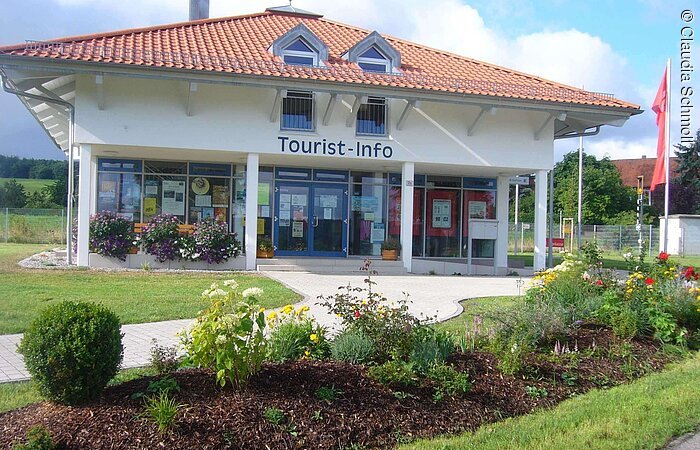 Außenansicht der Tourist-Info mit schön angelegten Beeten davor.