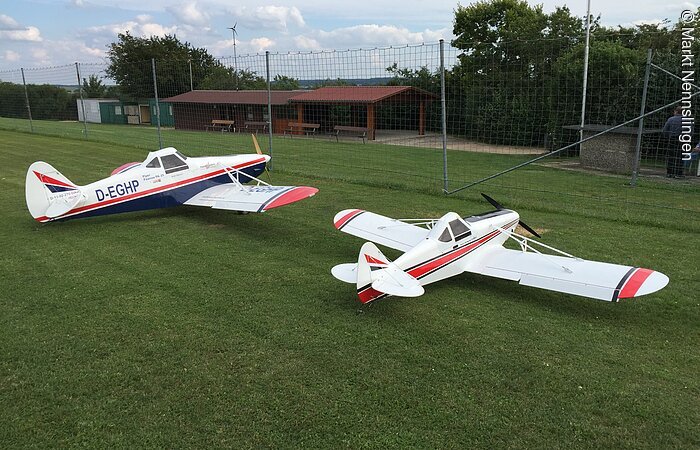 Zwei Modellflieger am Sportplatz.