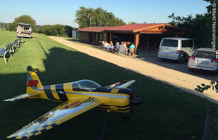 Gelbes Modellflugzeug am Sportplatz.