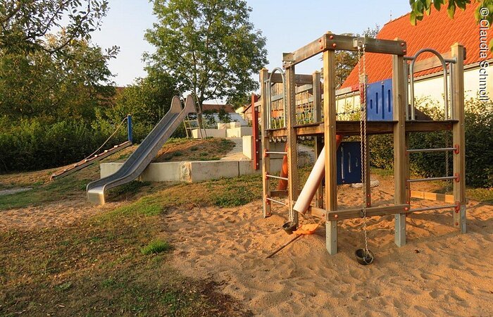 Metallrutsche und Klettergerüst auf einem Spielplatz.